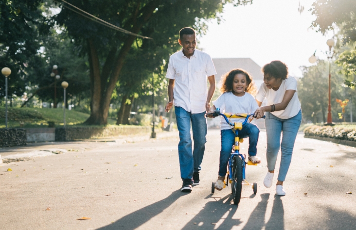 Family with young girl cycling